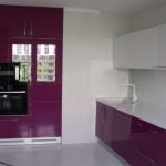 Diseño de cocina blanca y morada con ventana.