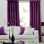 Almohadas moradas y blancas en un sofá blanco
