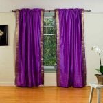 Habitación con cortinas moradas en la ventana.