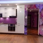 La combinación de muebles blancos y un delantal morado.
