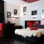 Colcha blanca y almohada roja en la cama