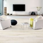 Dos sillones blancos frente al televisor.