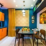 La combinación de paredes azules y muebles naranjas.