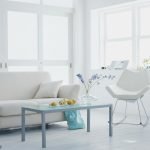 Una mesa de café azul frente a un sofá blanco.