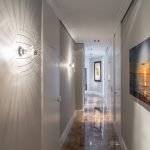 Corredor con cuadros y luces en la pared.