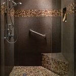 Azulejos marrones y mosaicos en el diseño de la ducha.