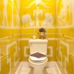 Azulejo amarillo con adornos blancos en el baño