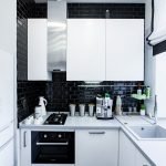 La combinación de un delantal negro y muebles blancos.