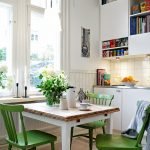 Sillas verdes alrededor de una mesa blanca