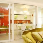 Una combinación de un delantal naranja y muebles blancos.