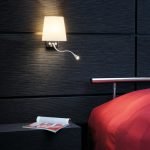 Dormitorio con una lámpara en la pared.