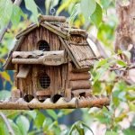 Casita para pájaros hecha de ramitas en un árbol