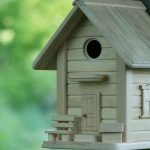Pajarera casera hecha de tablas con una puerta decorativa