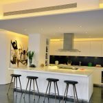 La combinación de muebles blancos y un delantal oscuro.