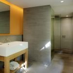 Pared amarilla en un baño gris