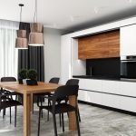 Cocina en blanco y negro con mesa marrón.