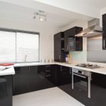 Cocina en blanco y negro con grandes ventanales.