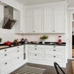 Muebles de cocina blancos con encimeras oscuras.