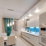 La combinación de muebles blancos y un delantal azul.