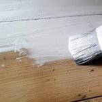 Dibujar pintura blanca sobre una superficie de madera