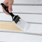 Pincel blanco pintando una silla