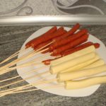 Ponemos salchichas y palitos de queso en brochetas